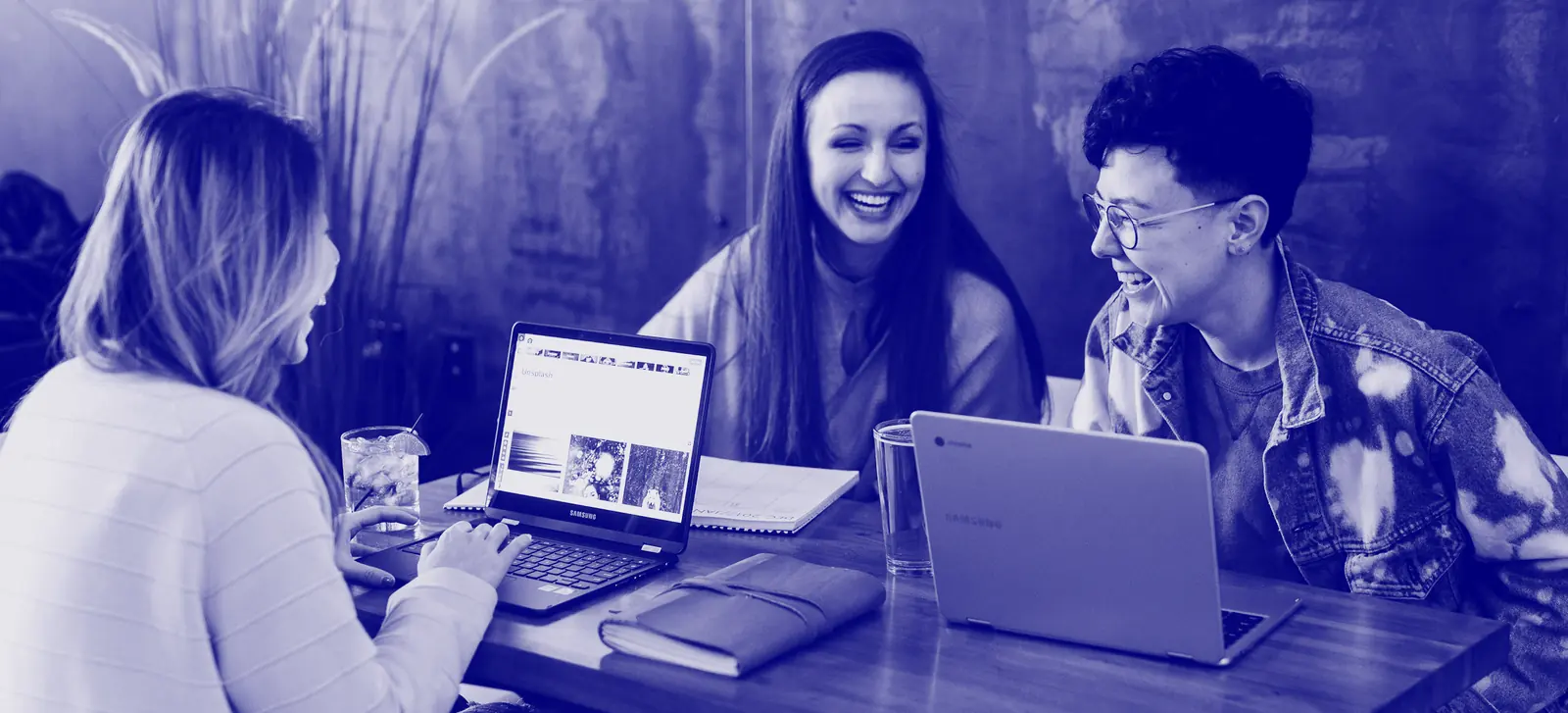 Tres personas riendo en una reunión de trabajo