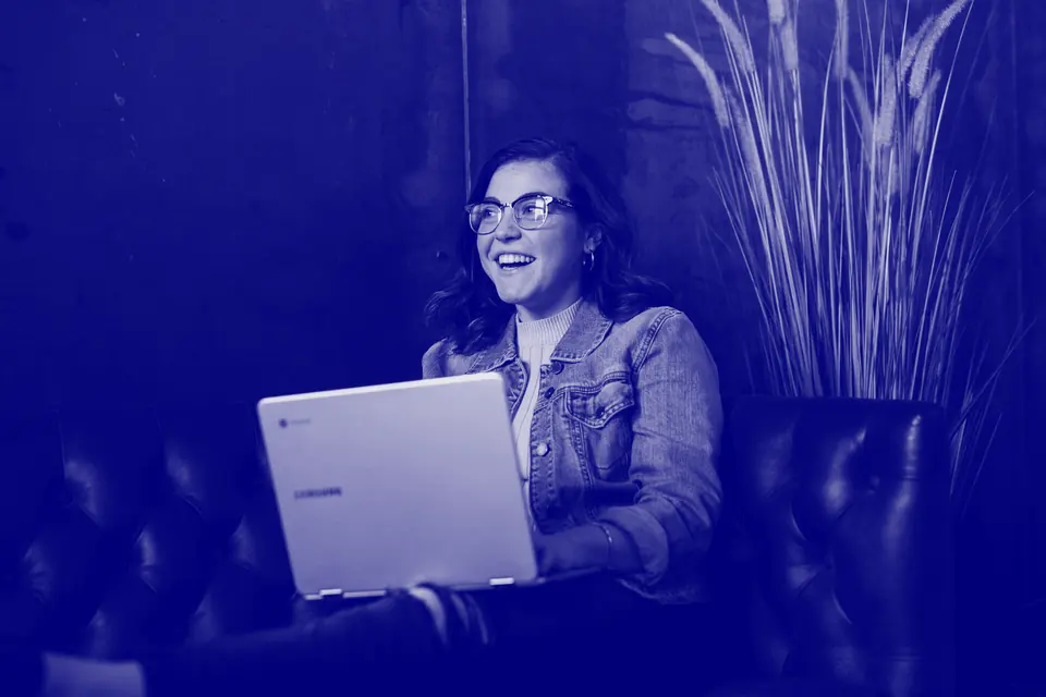 Young woman laughing in front of her laptop